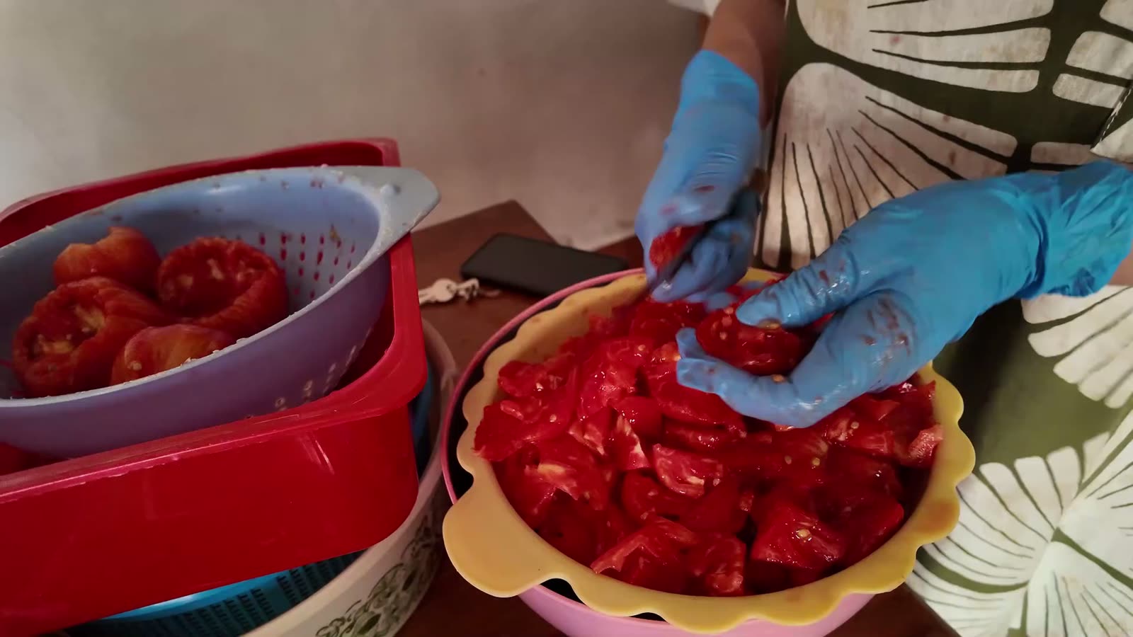 Tomate pelado y troceado en una fuente, junto al escurridor con el resto de tomates pelados
